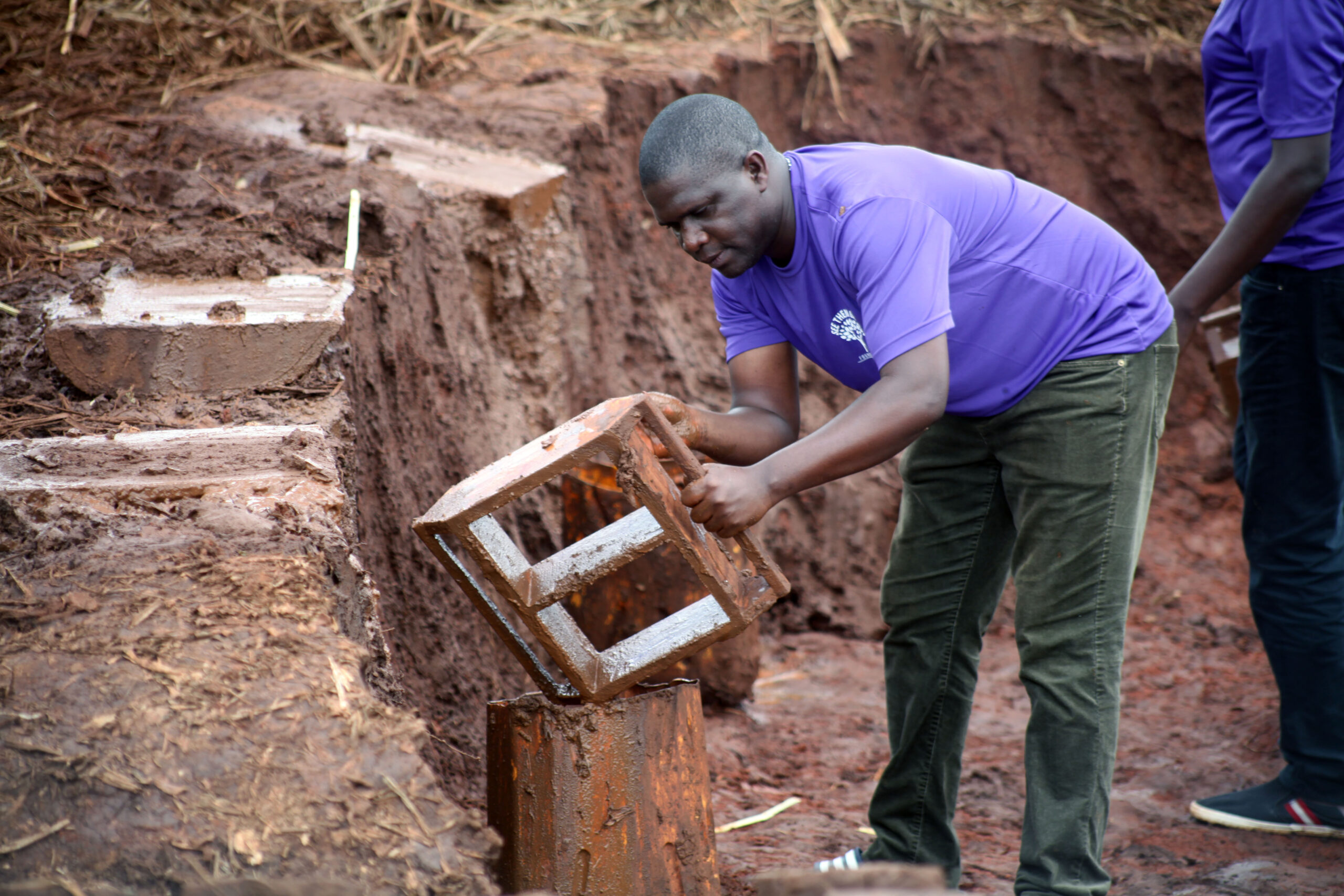 Our Founding director Laying bricks at our school site in Luuka